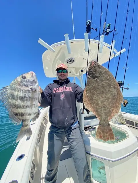 Angler aboard the Pathfinder holding two freshly caught fish